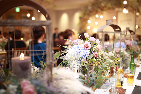 テーブルや壁に飾られた色とりどりの花やガーランド、キャンドルなどのグッズの写真