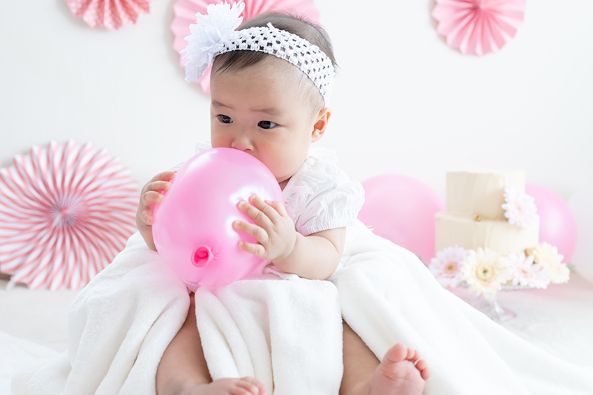 バルーンやガーランドで、おしゃれに飾り付けられた壁と赤ちゃんの写真